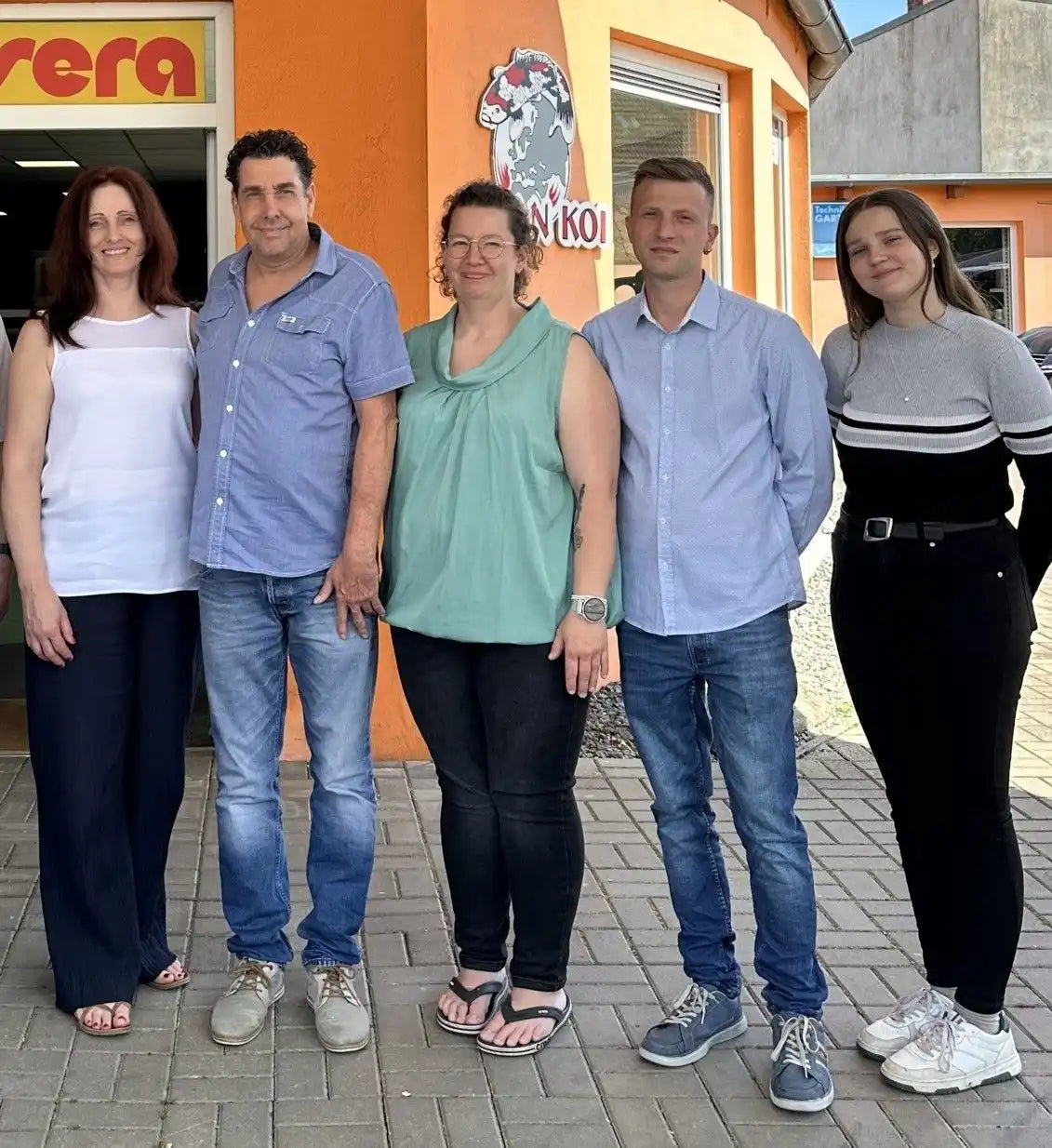 Fünf Menschen stehen draußen zusammen.