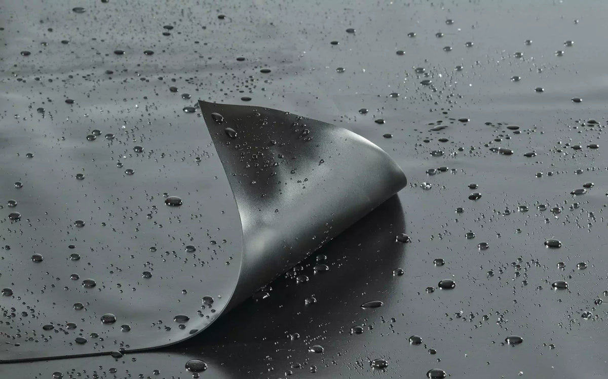 OASE AlfaFol black 1.0 mm / 12 x 15 m INT on a wet surface showing smooth texture and water droplets.